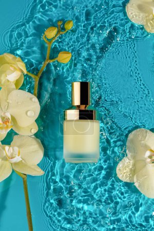 Luxurious moisturizing essence bottle with gold cap serenely floating among light yellow orchids on tranquil water surface. Concept of delicate skincare, fusion of botanical purity and skin hydration