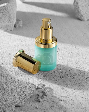 Contrast of textures: a delicate, nourishing skincare collection in elegant turquoise bottles with gold cap details against the rough and rugged gray surface of natural stone