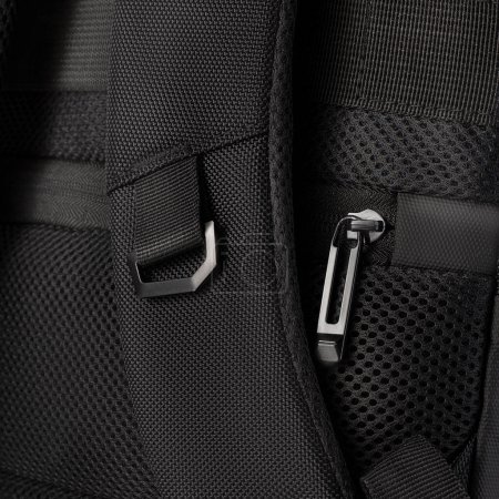 Sturdy black backpack designed with multiple zippered compartments and adjustable straps against grey background. Concept of  convenient stylish accessory for business trips and travel