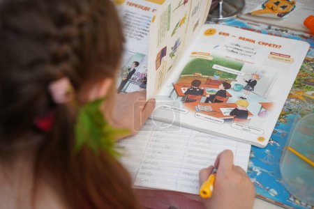Foto de Almaty, Kazakhstan - 05.18.2022 : The girl is doing school homework in her room. - Imagen libre de derechos