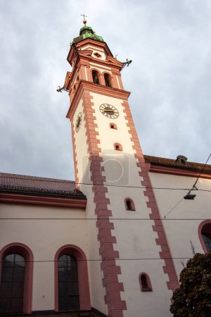Foto de Austria, Tirol, Innsbruck, campanario de la iglesia Servitenkirche en el fondo del cielo en las nubes - Imagen libre de derechos