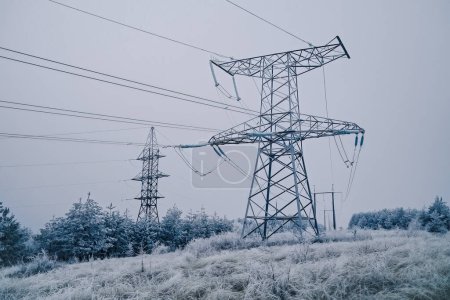 Foto de Torre de voltaje eléctrica, línea eléctrica, pilón de electricidad en el fondo de nieve de invierno. Foto de alta calidad - Imagen libre de derechos