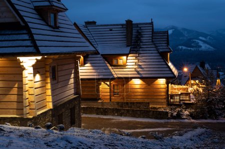 Foto de Noche hermosa casa de madera de pie en las montañas - Imagen libre de derechos