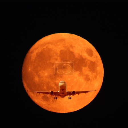 avión volador sobre el fondo de la luna roja
