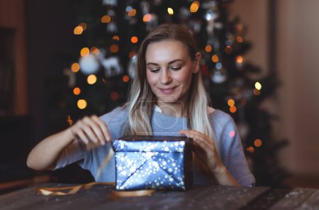 Foto de Retrato de una chica feliz disfrutando de regalos en casa en Nochebuena. Fondo decorado del árbol de Navidad Bokeh. Feliz Año Nuevo. Vacaciones de invierno - Imagen libre de derechos