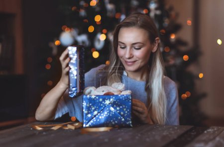 Photo for Portrait of a Happy Girl Enjoying Gifts at Home on Christmas Eve. Decorated Xmas Bokeh Tree Background. Happy New Year. Winter Holidays - Royalty Free Image