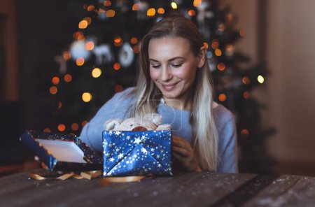 Foto de Retrato de una chica feliz disfrutando de regalos en casa en Nochebuena. Fondo decorado del árbol de Navidad Bokeh. Feliz Año Nuevo. Vacaciones de invierno - Imagen libre de derechos