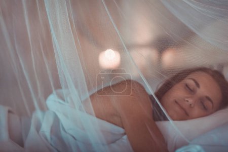 Téléchargez les photos : Belle femme calme dormant à la maison dans son lit. Sweet Dreams. Nuit pour se détendre et se réinitialiser - en image libre de droit