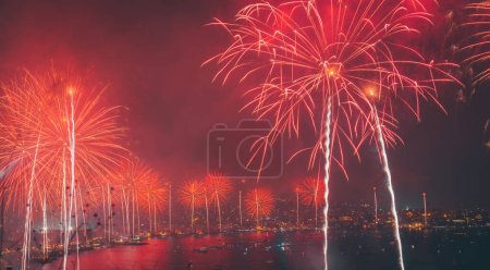 Téléchargez les photos : Célébration du Nouvel An. Superbe salut rouge sur l'eau Golfe la nuit. Joyeux Noël avec feux d'artifice festifs - en image libre de droit