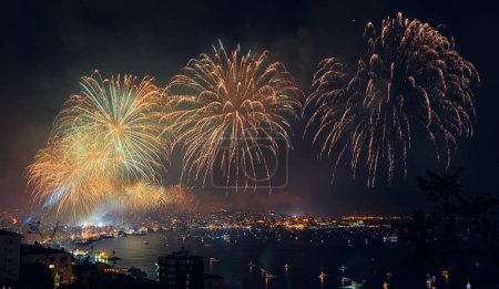 Foto de Celebrando las fiestas de Año Nuevo. Majestuoso Salute Over Coastal Cityscape en la noche. Feliz Navidad con fuegos artificiales coloridos - Imagen libre de derechos