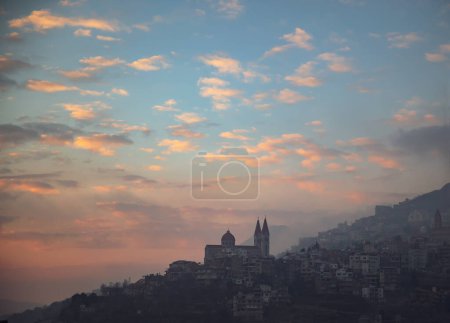 Téléchargez les photos : Silhouette of a Mountainous Church in Town over Beautiful Sunset Sky Background. Peaceful Panoramic View. Amazing Beauty of Lebanon. - en image libre de droit