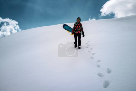 Téléchargez les photos : Active people enjoying the snow. Sports life and leisure. Snowboarder tourist girl walking on the mountain top. Ski park resort. Winter holidays and seasonal vacation travel. - en image libre de droit