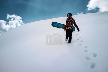 Téléchargez les photos : Active people enjoying the snow. Sports life and leisure. Snowboarder tourist girl walking on the mountain top. Ski park resort. Winter holidays and seasonal vacation travel. - en image libre de droit
