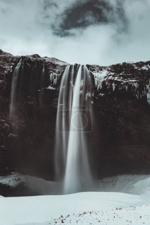Téléchargez les photos : Iceland. Beautiful landscape of Seljalandsfoss waterfall, located in South Region, amazing wintertime nature, beauty and strength of a wild nature. Vintage. - en image libre de droit