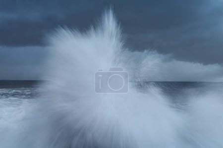 Téléchargez les photos : Slow Motion Photo of a Wave Splashes in the Water. Global Warming. Stormy Weather.Sea in Winter. Windy Weather - en image libre de droit
