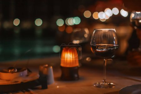 Photo for Romantic dinner in the restaurant. Warm cozy atmosphere with candlelight. Rendezvous. Glass of wine. Evening date. - Royalty Free Image
