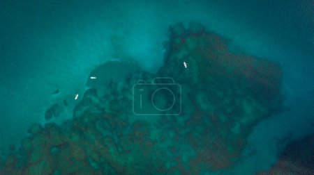 Photo for Aerial sea background. Amazing beautiful photo of a transparent water in Mediterranean. Drone view on a people riding a sup in the clear calm water - Royalty Free Image