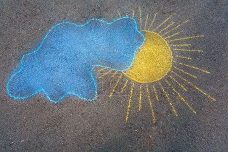 Téléchargez les photos : Beau fond abstrait. Dessin à la main à la craie sur asphalte d'un soleil jaune et d'un nuage bleu. Photo conceptuelle de la paix en Ukraine. - en image libre de droit