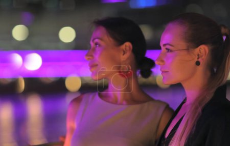 Photo for Portrait of two beautiful women on a night out. Best friends girls having fun in a club. Fashion look. Night city life. - Royalty Free Image