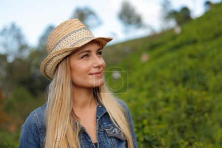 Téléchargez les photos : Portrait d'une femme rêveuse portant un chapeau de paille regardant loin de la verdure sur la station tropicale. Profiter de la nature exotique fraîche étonnante de Sri Lanka. - en image libre de droit
