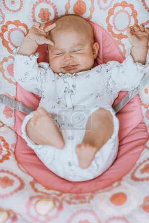 Photo for A cute little baby girl waking up, stretches her legs and arms in the crib. Attracting the attention of their loving parents. Happy healthy child at home. - Royalty Free Image