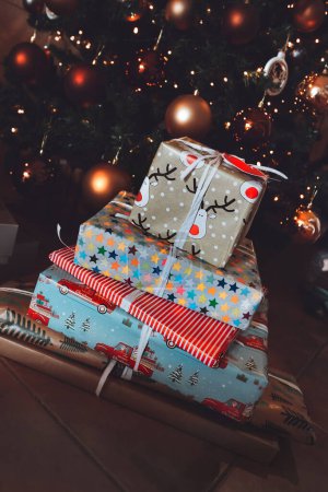 Foto de Montón de un montón de diferentes cajas de regalo de Navidad de colores acostados bajo el árbol de Navidad. Feliz mañana de Navidad. Regalos festivos tradicionales para niños - Imagen libre de derechos