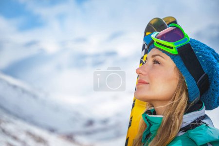 Foto de Retrato de una hermosa mujer disfrutando de una hermosa vista de la montaña de invierno. Linda chica preparándose para la pista de esquí. Felices vacaciones activas de invierno. - Imagen libre de derechos