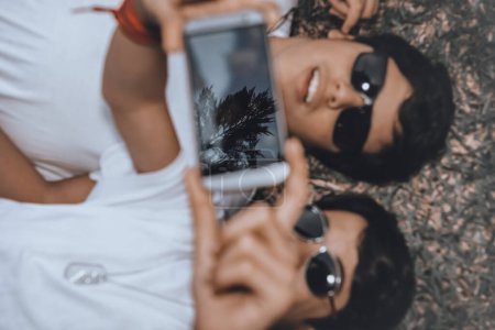 Photo for Two young guys wearing sunglasses, smiling happily, taking a memorable photo of the moment, friendship, emotions, and just a good sunny day. - Royalty Free Image
