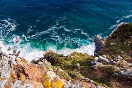 Téléchargez les photos : Vue aérienne sur un cap de Bonne-Espérance. Les vagues de mer battant contre le rivage rocheux créent de la mousse. Vacances d'été en Afrique du Sud. - en image libre de droit