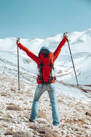 Téléchargez les photos : Bonne femme profitant des vacances d'hiver dans les montagnes. Des gens actifs marchant avec des bâtons dans les hautes montagnes. Mode de vie actif. - en image libre de droit