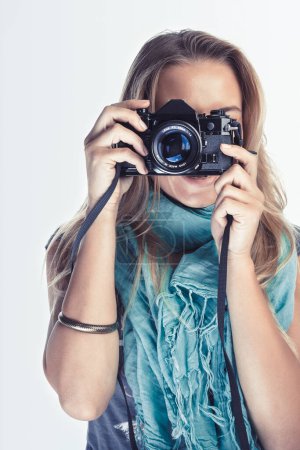 Foto de Una fotógrafa con una cámara en sus manos toma fotos de alguien. Sesión de fotos de moda. Ocupación moderna para los jóvenes. - Imagen libre de derechos