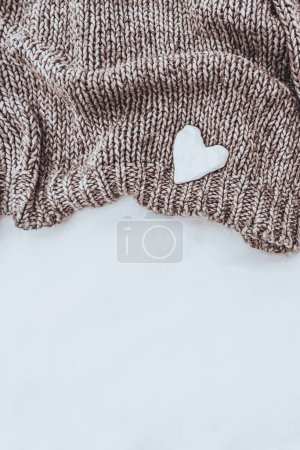 Téléchargez les photos : Laine chaude bordure en tissu tricoté isolé sur un fond blanc et décoré d'un joli petit cœur blanc. Photo avec espace texte et espace de copie. - en image libre de droit