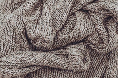Téléchargez les photos : Femmes pull tricoté plié occasionnellement. Des vêtements chauds et doux pour tous les jours. Le fond de laine symbolise à la fois le froid et la chaleur. - en image libre de droit