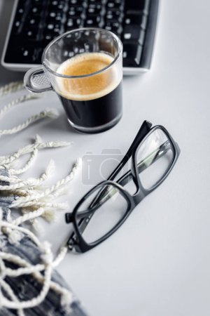 Téléchargez les photos : Tasse de café à côté des verres sur le bureau au bureau ou à la maison. Pause café. Journée de travail occasionnelle pour les gens d'affaires. - en image libre de droit