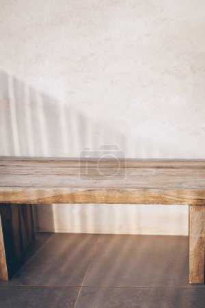 Téléchargez les photos : Un banc en bois élégant et confortable se dresse contre le mur d'une pièce lumineuse. La solution de conception idéale pour le style minimaliste. Confort, confort - en image libre de droit