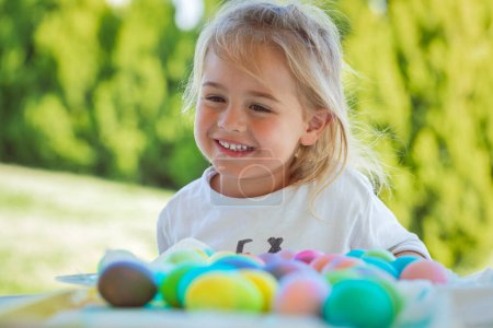Téléchargez les photos : Portrait d'un adorable enfant doux s'amusant, colorant les œufs à l'extérieur. Activités traditionnelles pour Pâques. Joyeuses fêtes religieuses de printemps. - en image libre de droit