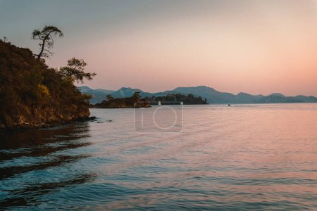 Téléchargez les photos : Paysage étonnant d'une île au milieu de la mer Méditerranée sous un léger coucher de soleil. Vacances d'été. - en image libre de droit