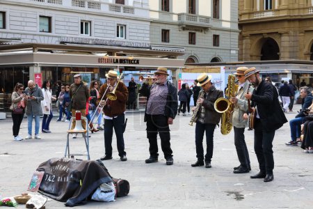 Téléchargez les photos : Florence, Italie - 16 avril 2023 : Le Old Florence Jazz Band joue de la musique sur la Piazza della Repubblica pour divertir les touristes et les habitants qui se promènent autour de cette place de la ville - en image libre de droit