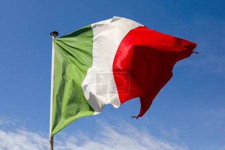 Le drapeau national de l'Italie est placé au sommet du mât et là, il ondule dans le vent et est visible contre un ciel bleu à Nice, en France