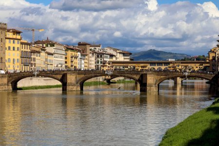 Téléchargez les photos : Florence, Italie - 15 avril 2023 : La rivière Arno traverse la ville dont les bâtiments et les ponts sont visibles ici. Le vieux pont, Ponte Vecchio est vu derrière le pont appelé Ponte Santa Trinita - en image libre de droit