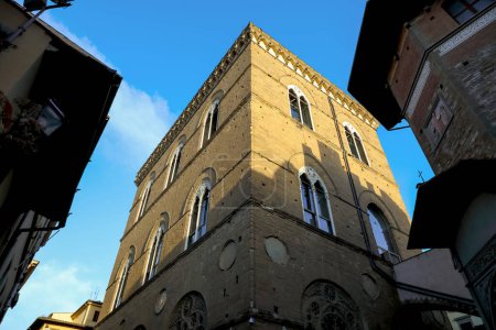 Foto de Florencia, Italia - 13 de abril de 2023: Sunlit Orsanmichele, Florencia iglesia de San Michele en Orto y ventanas arqueadas bipartitas visibles - Imagen libre de derechos