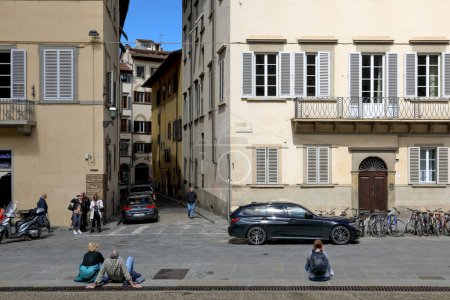 Téléchargez les photos : Florence, Italie - 15 avril 2023 : Carrefour dans la vieille ville. Ici, nous pouvons voir des maisons résidentielles avec quelques véhicules garés dans la rue et les gens qui regardent les sites de cette ville historique. - en image libre de droit