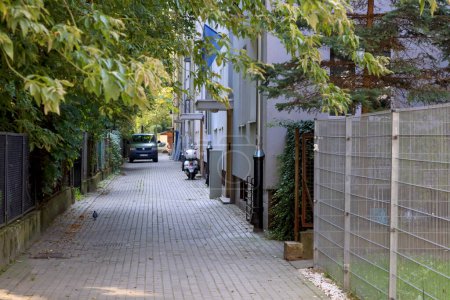 Téléchargez les photos : Varsovie, Pologne - 13 septembre 2023 : Une route courte, étroite et pavée entre une clôture et une rangée de bâtiments résidentiels dans le quartier Saska Kepa dans le quartier Praga-Poludnie. - en image libre de droit