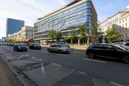 Téléchargez les photos : Varsovie, Pologne - 20 septembre 2023 : De l'autre côté de la route se trouve un centre commercial avec une façade en verre. Voitures se déplacent sur la route, que vous pouvez voir ici - en image libre de droit
