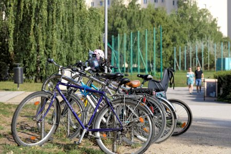 Téléchargez les photos : Varsovie, Pologne - 10 septembre 2023 : Vélos dans une aire de stationnement désignée pour vélos dans un parc municipal du lotissement Goclaw dans le district de Praga-Poludnie. - en image libre de droit