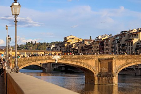 Téléchargez les photos : Florence, Italie - 16 avril 2023 : Ponte Santa Trinita est un ancien pont en arc de pierre qui enjambe le fleuve Arno. Ce pont est éclairé par les rayons du soleil couchant lentement. - en image libre de droit