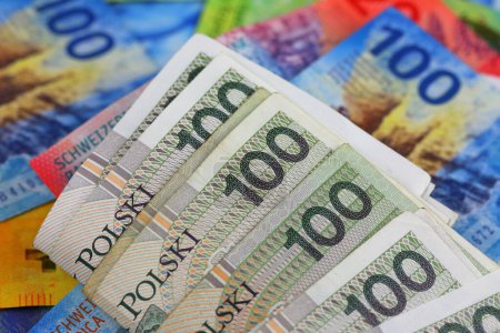 Varios billetes que muestran denominaciones de 100 zloty polaco y denominaciones de 100 francos suizos están codo con codo. Estos billetes se pueden utilizar para ilustrar muchos temas financieros diferentes. 