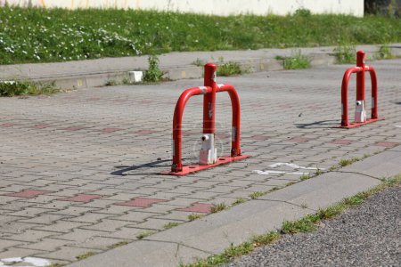 Metall-, falt- und abschließbare Poller aus weißem und rotem Stahlrohr wurden auf dem Parkplatz zur Markierung und zum Schutz des Privatparkplatzes in der Siedlung Goclaw in Warschau installiert.