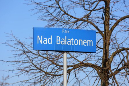 Nad Balatonem, eine weiße Inschrift auf blauem, rechteckigem Hintergrund auf einer Metallstange, ist der Name eines öffentlichen Parks in der Goclaw-Siedlung in Warschau, Polen.
