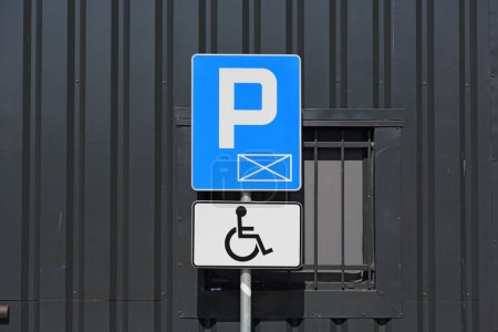 Foto de Señal de tráfico que indica el espacio de estacionamiento, en este caso aquí es signo de silla de ruedas adicional visible, que es un símbolo de la plaza de aparcamiento para discapacitados - Imagen libre de derechos